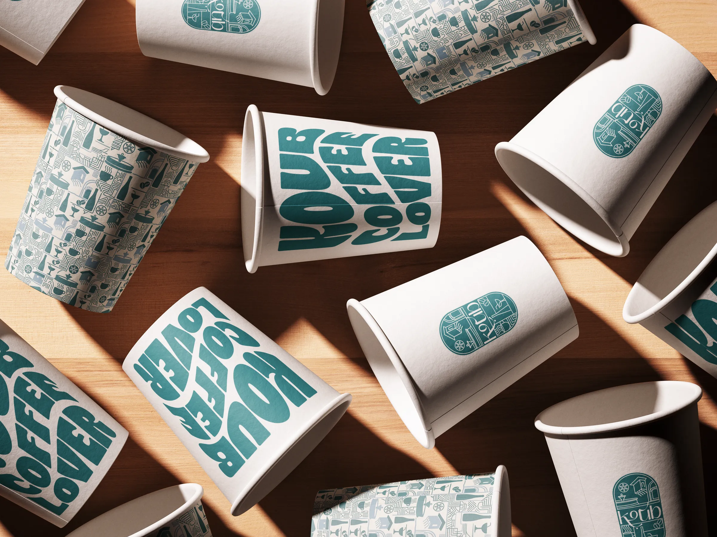 Koub branded coffee cups scattered on a wooden table