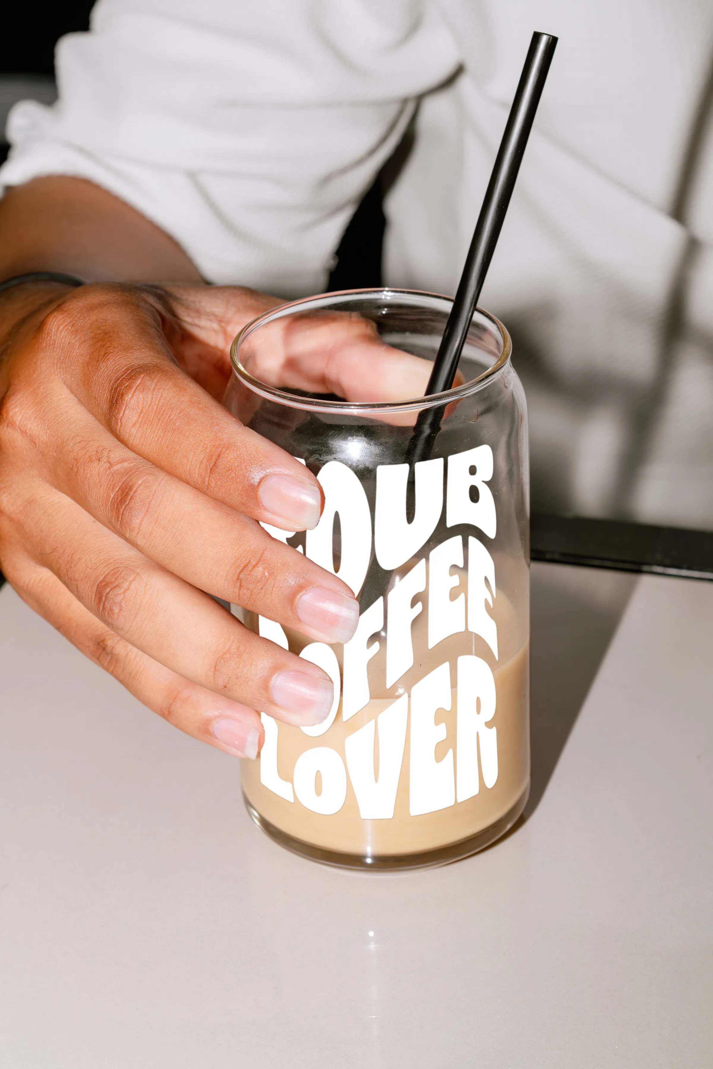 Koub branded iced coffee glass held in hand